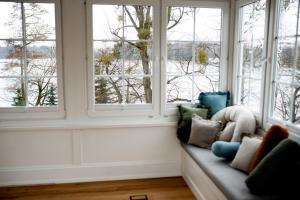 a couch in a room with three windows at Mały Sopot Boutique in Iława