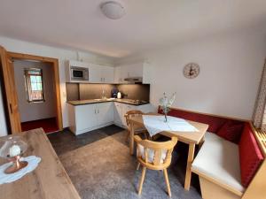 a kitchen and a living room with a table and a couch at Am Mühlrain in Sankt Anton am Arlberg