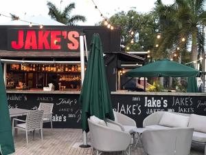 a restaurant with chairs and umbrellas in front of it at Coconut Court Beach Hotel in Bridgetown