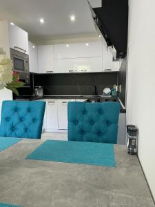 una cucina con 2 sedie blu di FineByt a Trenčianske Teplice