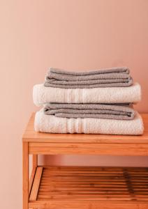 four towels stacked on top of a wooden table at Magna Grecia B&B e Appartamenti in Caulonia Marina +40 photos