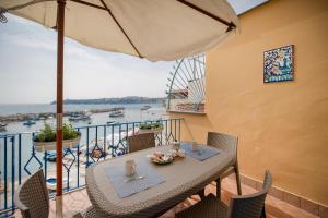 una mesa y sillas en un balcón con vistas al agua en Residence dei Pescatori, en Procida