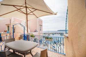 a table and chairs on a balcony with a view of the water at Residence dei Pescatori in Procida