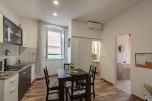 a kitchen and dining room with a table and chairs at Apartment Eša in Komiža