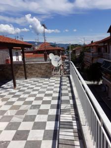 a balcony with a white chair on a roof at Dimitris appartment in Stavros +7 photos