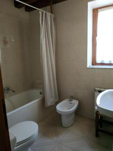 薩拉爾杜的住宿－Pension casat，浴室配有卫生间、浴缸和水槽。