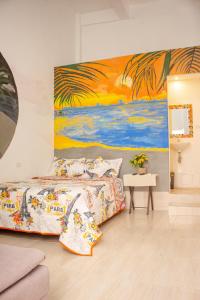 1 dormitorio con 1 cama y una pintura en la pared en Hostal Badillo SV en Cartagena de Indias