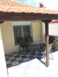 a patio with a table and chairs under a roof at Dimitris appartment in Stavros