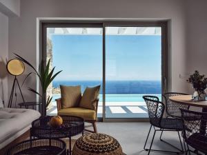 een woonkamer met uitzicht op de oceaan bij Etheria Luxury Villas & Suites in Agios Nikolaos