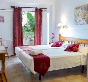 a bedroom with two beds and a window at Hostal Yebisah in Santa Eularia des Riu
