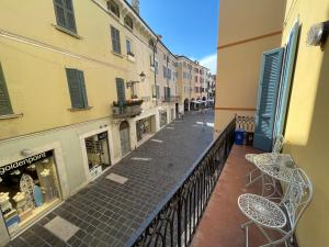 un balcone con tavoli e sedie su una strada della città di DesenzanoLoft Le Petit Bijou Desenzano a Desenzano del Garda