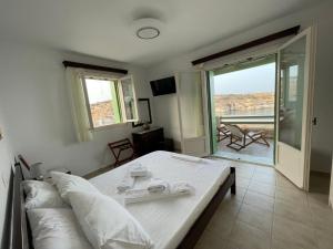 a bedroom with a bed and a view of a balcony at Remezzo Kimolos in Kimolos