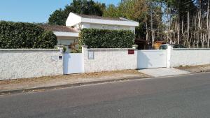 a white fence in front of a house at Maison Lucilda in Pessac