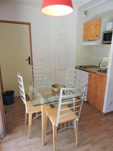 - une table à manger et des chaises dans la cuisine dans l'établissement Le Hameau SPA & PISCINE studio 4pers by Alpvision Résidences, à Orelle