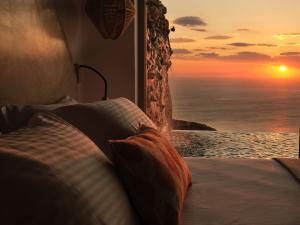 een slaapkamer met een bed en uitzicht op de oceaan bij Etheria Luxury Villas & Suites in Agios Nikolaos