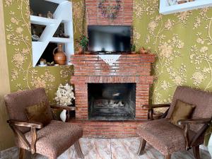 a living room with two chairs and a fireplace at Garden House in Kvareli