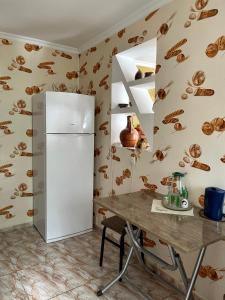 eine Küche mit einem Kühlschrank und einem Tisch in der Unterkunft Garden House in Qwareli