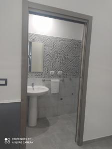 y baño con lavabo y espejo. en MONOLOCALE-ALI', en Alì