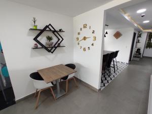 a dining room with a table and a clock on the wall at Hostel Boutique Nido de Loros in Medellín