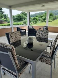 a dining table and chairs on a porch at Apartment Gorska vila in Ogulin
