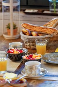 einen Tisch mit Schalen Obst und einem Korb Brot in der Unterkunft O'Jane de Boy in Lège-Cap-Ferret