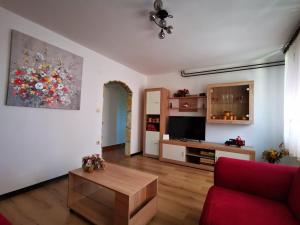 een woonkamer met een rode bank en een tafel bij Apartman Ornela in Delnice