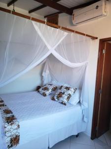 uma cama branca com duas almofadas em cima em Casa da Lau em Trancoso