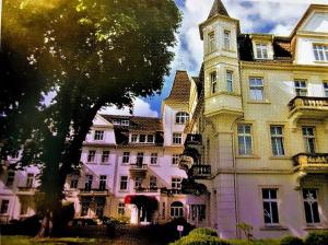 ein großes Gebäude mit einem Uhrturm neben einem Baum in der Unterkunft Gemütliche Maisonette am Kurpark in Bad Rothenfelde