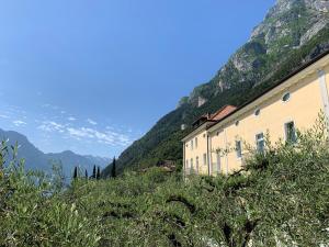 a building on a hill with mountains in the background at Aparthotel Englovacanze in Riva del Garda