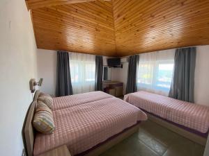 a bedroom with two beds and a wooden ceiling at Villas Sozopol in Sozopol +82 photos