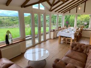 un soggiorno con tavolo, sedie e finestre di Fernside Bed and Breakfast a Templeton