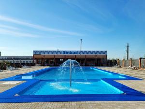 a fountain in a pool in front of a building at Delta Hotel in Vylkove