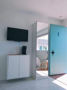 a living room with a flat screen tv and a blue door at En route vers l’infini in Perce