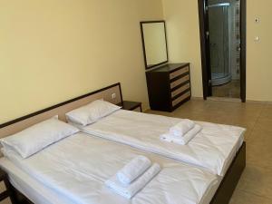 een groot wit bed met 2 handdoeken erop bij 3 Room Family Apartment with Pool View (4 min. away from the Sea) in Nesebar