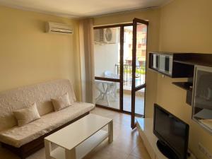 een woonkamer met een bank en een tv bij 3 Room Family Apartment with Pool View (4 min. away from the Sea) in Nesebar