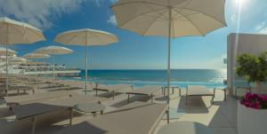 a row of tables and chairs with umbrellas on a beach at RH Bayren Hotel & Spa 4* Sup in Gandía