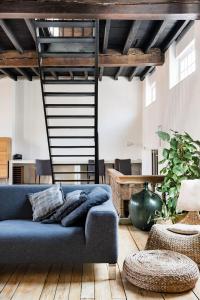 a living room with a blue couch and a ladder at PAKHUIS in Ghent