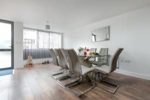 ein Esszimmer mit einem Tisch und Stühlen in der Unterkunft KVM - City Apartments, town centre with parking by KVM Stays in Peterborough