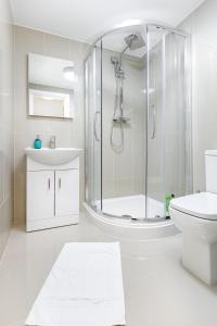 a white bathroom with a shower and a toilet at KVM - City Apartments in Peterborough +114 photos