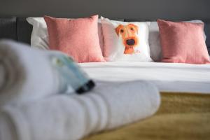 a stuffed dog sitting on a bed with pillows at Bank Side House by KVM Stays in Peterborough