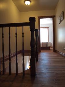 a hallway with a staircase and a living room at Chalet Rouge in New Richmond