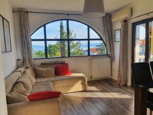 a living room with a couch and a large window at Villa Flora in Malinska