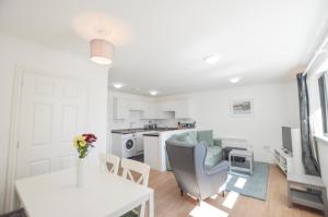 a kitchen and living room with a table and a couch at No 8 Westbay Apartment in Oban