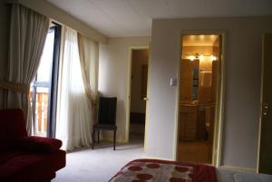 a living room with a door open to a bathroom at Villa Baviera, Hotel Baviera Chile in La Máquina
