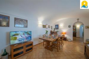 een eetkamer met een tafel en een flatscreen-tv bij Casa Francisca in Praiano