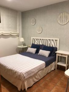 a bedroom with a large bed with blue and white sheets at Apartamento Casas del Mar in Oliva +19 photos