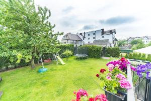 un patio con parque infantil y flores en el balcón en ZARA pokoje gościnne, en Władysławowo