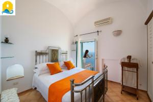 een slaapkamer met een bed met oranje kussens bij Casa Francisca in Praiano +23 foto's