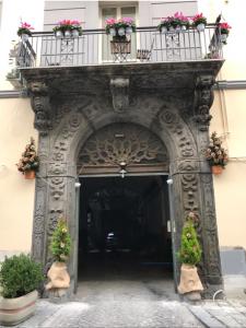 ナポリにあるVarriale Houseの花の咲くバルコニー付きの建物への入り口