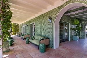 an outdoor patio with couches on a green wall at The Colony Palms Hotel and Bungalows - Adults Only in Palm Springs
